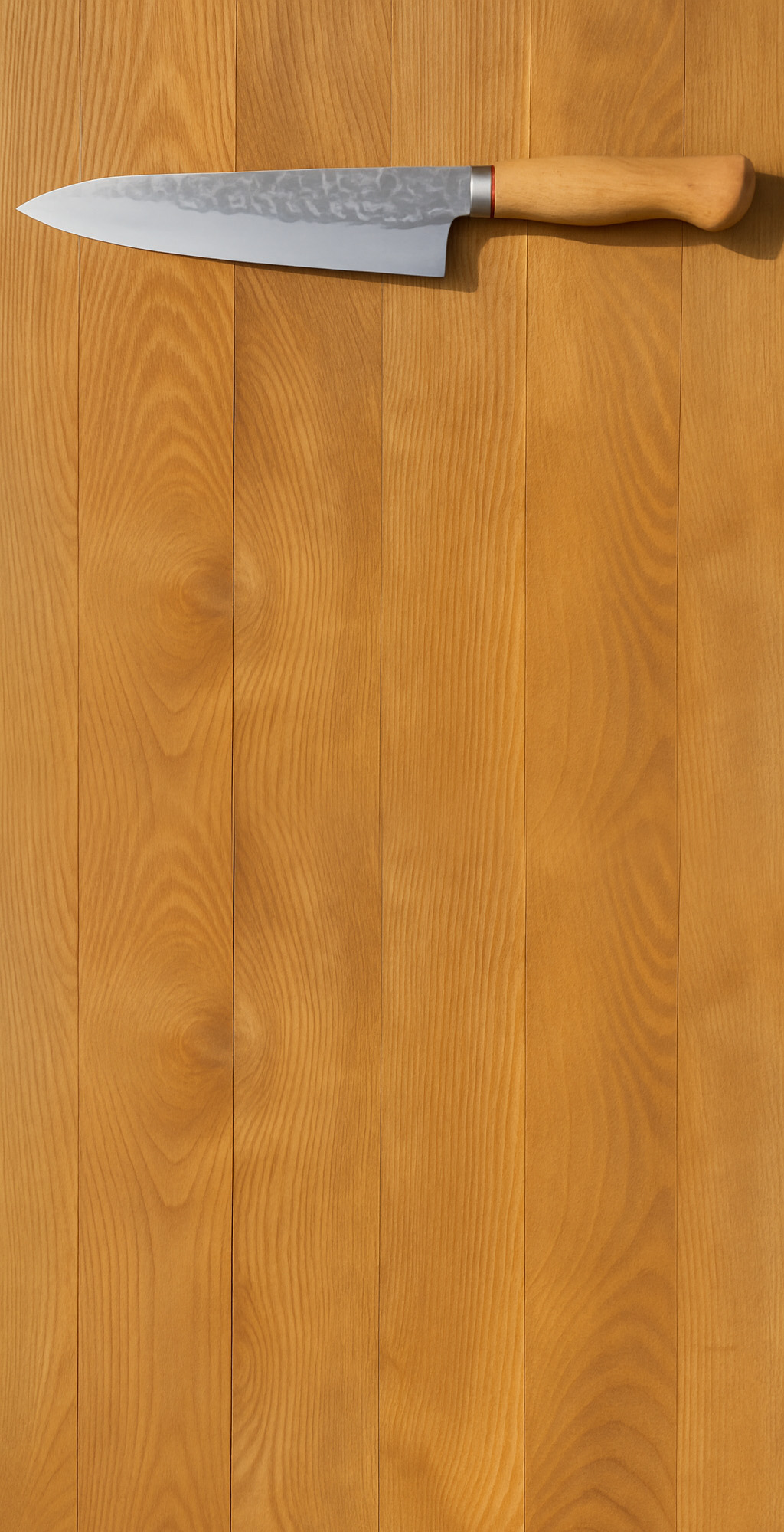 Professional knife on wooden cutting board with fresh ingredients